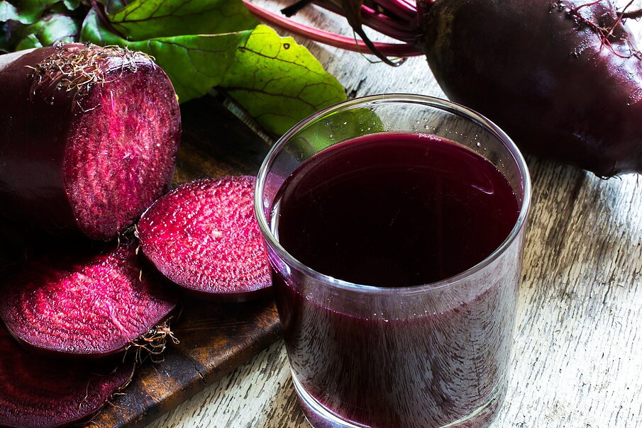 Vaso de zumo de remolacha natural y rodajas de remolacha fresca rica en nitratos dietéticos